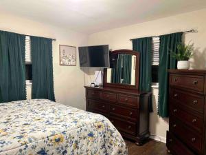 a bedroom with a bed and a dresser with a mirror at Cozy Home Away from Home in Clayton