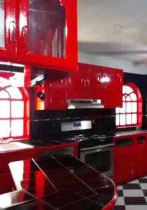 a kitchen with red cabinets and a stove top oven at Presidential Suite in Tijuana
