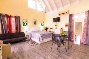 1 dormitorio con cama, sofá y mesa en Sunsets at Sunshine Village Lofts, en Negril