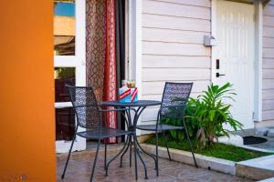 una mesa de patio y sillas en un porche en Sunsets at Sunshine Village Lofts, en Negril