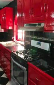 a red kitchen with a stove and red cabinets at Presidential Suite in Tijuana