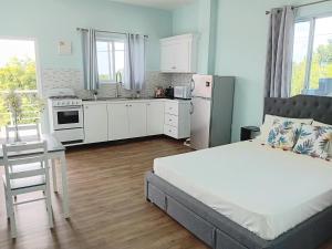 a bedroom with a bed and a kitchen at Serenity Seaview Suite in Anse La Raye