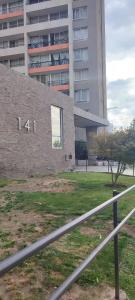 un muro di mattoni con il numero sopra di fronte a un edificio di Departamento pasos Mall Plaza Vespucio a Santiago