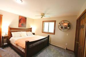 a bedroom with a bed and a window and a mirror at Stairway To Heaven-VT Lakefront! in Eden