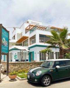 een groene auto geparkeerd voor een huis bij Kauhuhu Casa Hotel in San Bartolo