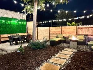 a patio with a table and a fire pit at night at North Oakland Home w/ 70s Lounge+Patio in Oakland