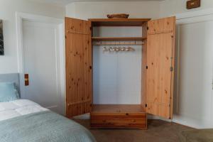 a bedroom with a wooden cabinet next to a bed at North Oakland Home w/ 70s Lounge+Patio in Oakland