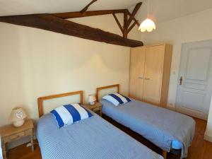 - une chambre avec 2 lits dotés d'oreillers bleus et blancs dans l'établissement Gîte Bréville, 4 pièces, 6 personnes - FR-1-653-104, à Bréville