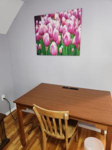 uma mesa de madeira com uma pintura de tulipas cor-de-rosa em Winnipeg Place to Stay em Winnipeg