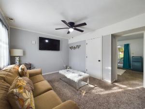 a living room with a couch and a ceiling fan at Pine Forest Zen Cottage - 10 min to Fort Bragg in Fayetteville