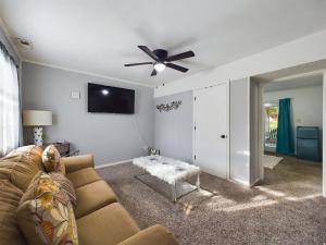a living room with a couch and a ceiling fan at Pine Forest Zen Cottage - 10 min to Fort Bragg in Fayetteville