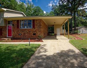 uma casa de tijolos com uma porta vermelha e uma entrada em Pine Forest Zen Cottage - 10 min to Fort Bragg em Fayetteville