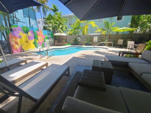 a pool with tables and chairs and an umbrella at Duval Street Suite with pool in Key West