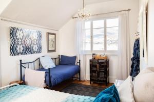 a bedroom with a blue bed and a window at Assemblage Boutique Art B & B in Hobart