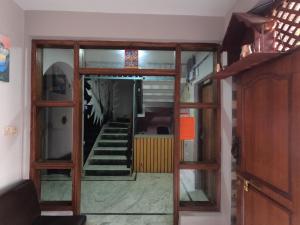 - un couloir avec des portes en verre et des escaliers dans une maison dans l'établissement Hello KTM Hostel, à Katmandou