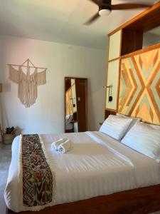 a bedroom with a large bed with two towels on it at Chief Mau Moalboal Cebu in Moalboal