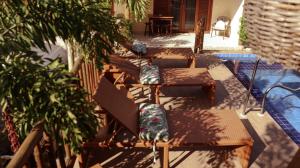 a row of benches with pillows on a patio at Pousada Lua Nova Charmosa Pipa in Pipa