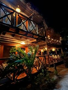 a building with a wooden roof at night at Thani Ecobeach Barú in Playa Blanca +93 photos