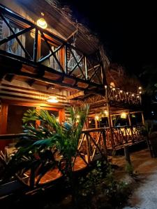 a building with a wooden roof at night at Thani Ecobeach Barú in Playa Blanca