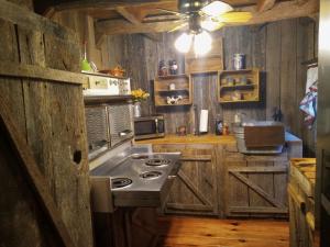 cocina con paredes de madera y horno con fogones en The Little Cabin on Huckleberry en Rural Retreat