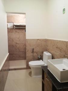 a bathroom with a white toilet and a sink at Montevideo Boutique Homestay in Shillong