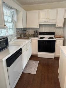 a kitchen with white cabinets and a black stove top oven at The Mirror Lake Suite in Fayetteville