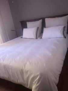 a white bed with two pillows on top of it at Jo's Eden in Edenvale
