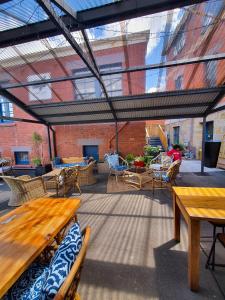 un patio al aire libre con mesas y sillas de madera en Assemblage Boutique Art B & B, en Hobart