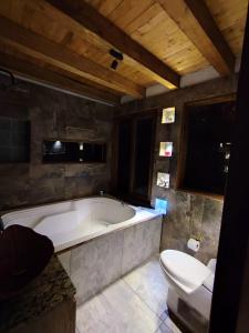a large bathroom with a tub and a toilet at cabaña paniym in Rionegro