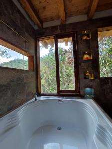 a large bath tub in a room with two windows at cabaña paniym in Rionegro