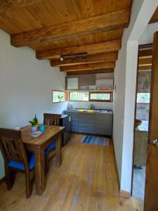 a kitchen with a wooden table and wooden ceilings at cabaña paniym in Rionegro