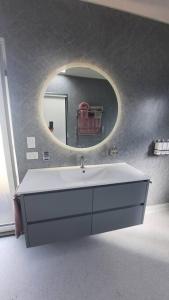 a bathroom with a white sink and a mirror at Private Getaway Close to Clifton Beach in Hobart