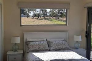 um quarto com uma cama com uma janela por cima em Private Getaway Close to Clifton Beach em Hobart