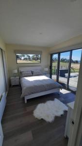 a bedroom with a bed and a large window at Private Getaway Close to Clifton Beach in Hobart