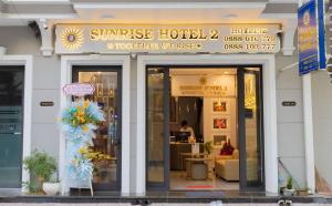 una tienda frente a un hotel con flores en la ventana en SUNRISE Hotel Bạc Liêu en Bạc Liêu