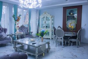 a living room with a table and chairs and a chandelier at Rovie Estates in Buea