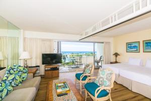 ein Hotelzimmer mit einem Bett und einem Wohnzimmer in der Unterkunft Ilikai Tower 618 Lagoon View 1BR in Honolulu