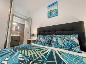 Schlafzimmer mit einem großen Bett mit blauer und weißer Bettwäsche in der Unterkunft KOOKA NUI LODGE - Free Wifi & Parking in Papeete