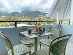 a table and chairs on a balcony with a view of mountains at KOOKA NUI LODGE - Free Wifi & Parking in Papeete