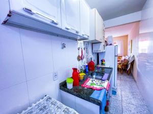 uma pequena cozinha com um balcão e um frigorífico em Casa na Praia de Guaratiba - Maricá em Maricá