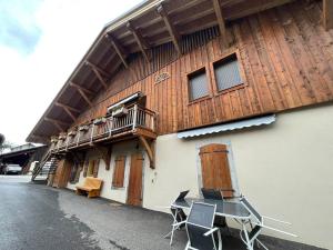 a building with a table and chairs in front of it at Appartement Morillon Village, 3 pièces, 5 personnes - FR-1-624-141 in Morillon