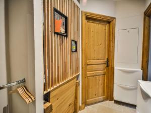 a bathroom with a toilet and a wooden door at Appartement Morzine, 3 pièces, 6 personnes - FR-1-684-65 in Morzine