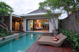 a villa with a swimming pool and a house at Berry Amour Romantic Villas in Seminyak