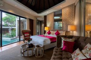 a bedroom with a bed and a couch at Berry Amour Romantic Villas in Seminyak
