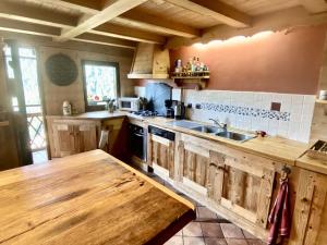 a kitchen with wooden cabinets and a wooden table at Chalet 4 pièces avec balcon, BBQ, parking, WIFI à Châtel - FR-1-676-43 in Châtel