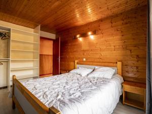um quarto com uma cama numa parede de madeira em Appartement Châtel, 4 pièces, 6 personnes - FR-1-676-60 em Châtel