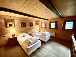 a room with two beds in a log cabin at Chalet 4 pièces, 3 chambres, 8 pers., proche télécabine, balcon, jardin privatif, parking, Wifi - FR-1-676-40 in Châtel