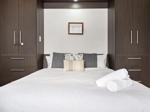 a bedroom with a large white bed with wooden cabinets at Celesia 2 in Thredbo