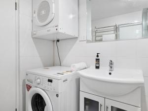 a white laundry room with a washing machine and a sink at Celesia 2 in Thredbo