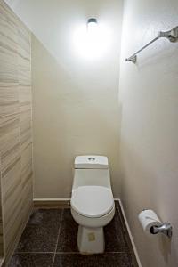 La salle de bains est pourvue de toilettes et d'une lumière sur le mur. dans l'établissement hotel isla Bonita, à Zihuatanejo
